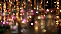 Festive golden and pink bokeh lights hanging from above creating magical holiday atmosphere for celebrations and special events.