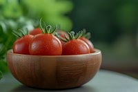 Fresh ripe cherry tomatoes with water drops in wooden bowl against dark green background, selective focus for food photography and healthy eating.