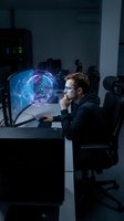 Caucasian male programmer analyzing holographic brain data visualization on computer screen in modern tech office workspace for artificial intelligence development.