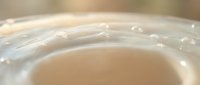 Close-up macro shot of creamy white cosmetic texture with smooth surface and gentle bubbles, skincare product for beauty and wellness applications.