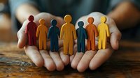 Protective hands holding diverse colorful human figures representing teamwork, inclusion, community support, and social responsibility in workplace.