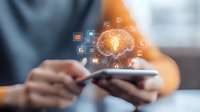 Digital brain with glowing light bulb and icons floating above smartphone in hands, representing artificial intelligence and mobile technology innovation.