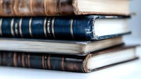 Stack of vintage leather-bound books with worn spines and aged pages creating scholarly atmosphere for education, literature, and academic research projects.