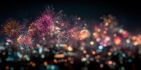 Vibrant fireworks display illuminating night sky with colorful bursts of pink, orange, and gold against blurred city lights backdrop.