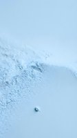 Fine light blue powder scattered across smooth surface with soft shadows and gradient background, suitable for cosmetics, skincare, and beauty product marketing.