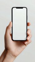 Hand holding modern smartphone with blank white screen mockup for app presentation and mobile interface design projects on neutral background.