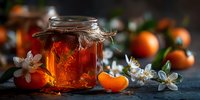 Golden orange blossom honey in glass jar with fresh citrus fruits and delicate white flowers on rustic wooden surface for natural organic food concepts.