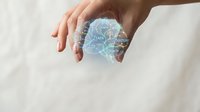 Hands holding holographic brain with neural network connections representing artificial intelligence and machine learning technology concepts.