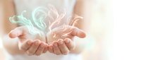 Young woman's cupped hands holding glowing swirling energy light in soft pastel tones, symbolizing healing, spirituality, and inner peace.