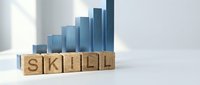 Blue bar chart with ascending steps and wooden blocks spelling SKILL representing professional development and career growth in business training.