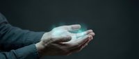 Hands cupping glowing turquoise energy orb against dark background symbolizing power, healing, magic, spirituality and mystical forces in conceptual art.