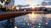 Modern urban waterfront at sunset with light poles reflecting on water surface and city skyline in background. Golden hour ambiance.