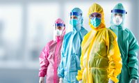 Medical staff in colorful protective suits, face masks and shields standing in hospital corridor. Healthcare workers in PPE during pandemic outbreak.
