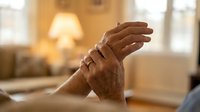 Senior woman massaging arthritic hands at home, elderly healthcare and joint pain relief concept for medical wellness treatment.