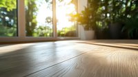 Sunlit wooden floor with natural light streaming through window, creating warm shadows and highlighting wood grain texture in empty modern room with potted plant.
