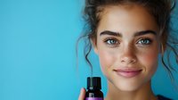 Young woman with freckles and bright blue eyes holding essential oil bottle against turquoise background, showcasing natural beauty and skincare concept.