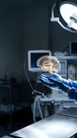 Surgeon hand in blue glove holding glowing brain hologram in modern operating room with medical equipment for neurosurgery and healthcare technology concepts.