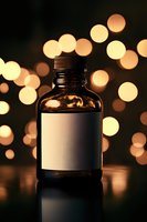 Dark glass bottle with blank label against blurred golden bokeh lights background, creating atmospheric mood for product photography and marketing materials.
