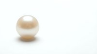Single lustrous cream pearl with natural iridescent surface on clean white background. Elegant jewelry element isolated for luxury design projects.