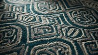 Intricate teal and beige geometric embroidered textile with ornate swirl patterns and detailed stitching for luxury interior design and fabric backgrounds.