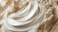 Creamy white frosting with smooth swirls and peaks, rich texture for baking, dessert decoration, culinary arts, food styling and confectionery designs.