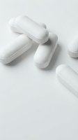 White pharmaceutical capsules scattered on clean background for medical and healthcare design projects.