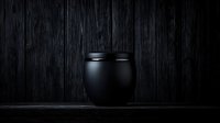 Minimalist black ceramic pot on dark wooden background with dramatic lighting and deep shadows creates moody atmospheric composition.