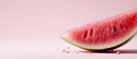 Fresh juicy watermelon slice on pink background with scattered seeds, minimalist summer food composition showing bright red flesh and green rind.