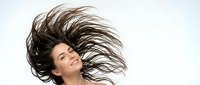Young woman with long brown hair in dynamic motion against white background for beauty and lifestyle advertising campaigns.