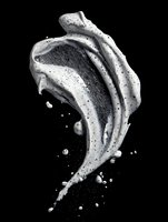 Dynamic monochrome splash of cream or paint frozen in motion against black background, creating abstract fluid shape with droplets and organic curves.