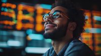 Young African American man with glasses smiling confidently against blurred urban night lights background, expressing joy and optimism in modern city setting.