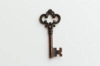 Vintage ornate bronze skeleton key with decorative bow design photographed on white background, isolated object for design projects and creative use.