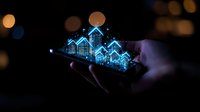 Glowing blue holographic houses rising from smartphone screen in dark environment with bokeh lights, representing digital real estate and smart home technology.