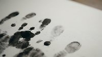 Fingerprints and handprints in black ink on white paper, forensic evidence collection for criminal investigation, identification, and security purposes.