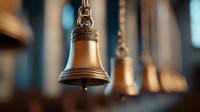 Decorative brass bells hanging in row with shallow depth of field, warm lighting creates nostalgic atmosphere. Antique metalwork details visible on traditional design.