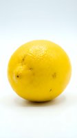 Fresh yellow lemon with textured peel and natural blemishes on white background. Use for food, nutrition, cooking, beverage, and wellness content.