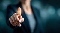 Close-up of businessperson in formal attire pointing finger at virtual interface against dark blue background, concept for digital technology and corporate innovation.