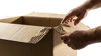 Hands opening corrugated cardboard box with tape on white background, isolated for packaging, shipping, delivery, and logistics design use.