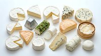 Assorted gourmet cheese collection featuring brie, camembert, blue cheese, goat cheese and aged varieties arranged on white background for culinary design.