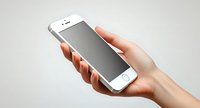 Female hand holding modern white smartphone with blank screen against light background, mockup for app or website presentation.