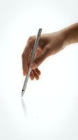 Male hand holding modern silver pen in writing position on white background for business and office concepts.