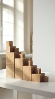 Wooden staircase blocks arranged in ascending steps on white surface with natural light from window, symbolizing growth, progress and business success.