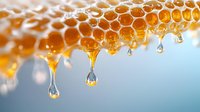 Fresh honey drips from golden honeycomb cells in droplets against blue background, macro photography showing natural organic sweetness and beekeeping harvest.