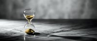Golden sand hourglass on wooden surface with blurred background symbolizing time passage, deadline pressure, and life moments for business concepts.