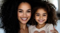Happy African American mother and daughter with curly hair smiling together at home showing family love and bonding in warm indoor setting.