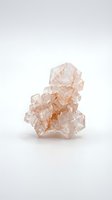 Isolated peach-colored topaz crystal cluster with geometric facets on white background, ready for mineral education, geology presentations, and design applications.