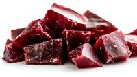 Fresh raw beetroot cut into cubes on white background, close up view showing natural texture and deep red color. Healthy vegetable ingredient for cooking.