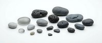 Collection of smooth river rocks and pebbles in various sizes arranged on white background, perfect for spa decoration and zen garden design.