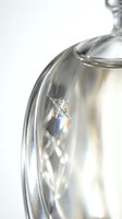 Close-up of spider web with dewdrops on reflective metal teapot surface creating natural patterns and textures for kitchen and nature photography concepts.