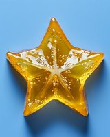 Yellow translucent star shape with liquid texture and bubbles on blue background, glowing from within. Clean minimal composition for creative design projects.